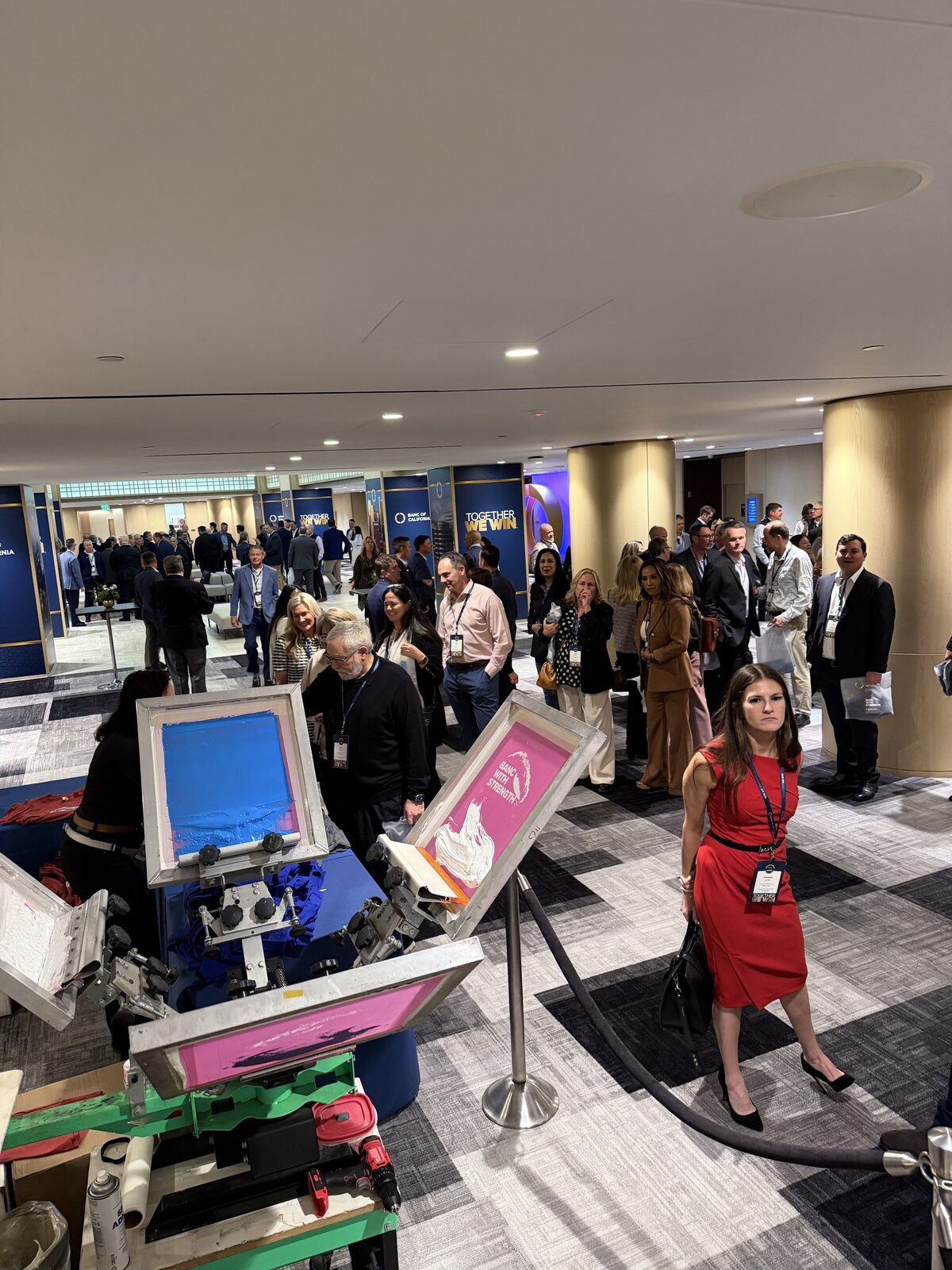 Wedding guests lined up at a live printing station during a reception