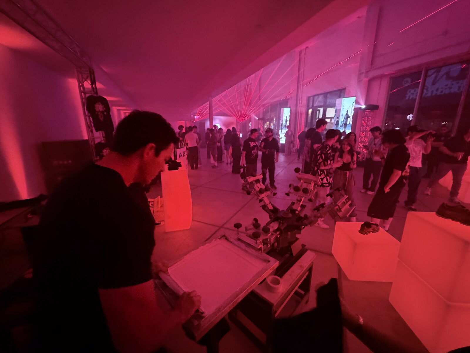 Guests gathered around a glowing live printing station at an evening reception